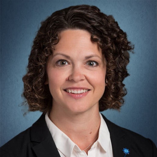 headshot of Kelly with dark blue background