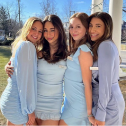 4 Sigma Delta Tau sisters wearing dresses in various styles and shades of blue.