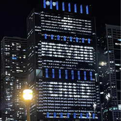 The Blue Cross Blue Shield Building in Chicago, IL at night, with blue lights.